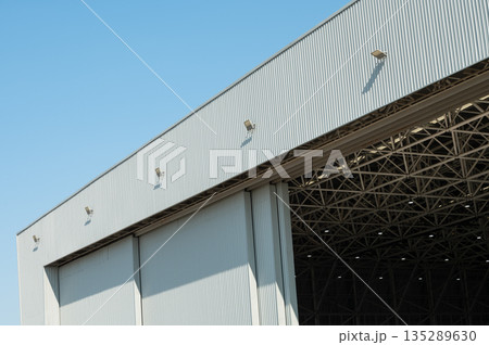 Large industrial warehouse building with sliding metal doors 135289630