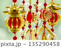 Decorative red and gold lanterns arranged vertically symbolizing celebration and good fortune. 135290458