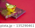 Gold Chinese sycee placed on layered red envelopes with festive background for Lunar New Year prosperity concept. 135290461
