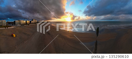 Experience the Breathtaking Sunset that Dances over the Ocean Beach with Dramatic Clouds 135290610