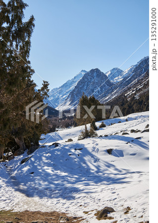 Snow covered mountain landscape with footprints in a valley. Winter scene 135291000