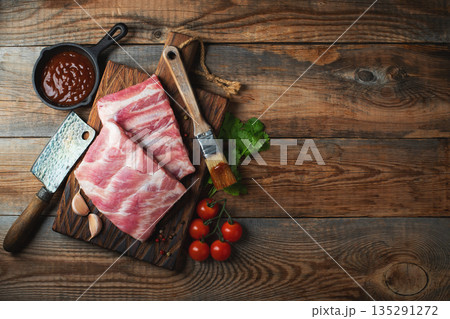 Raw pork ribs with spices, salt and rosemary on dark wooden background 135291272