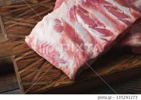 Raw pork ribs with spices, salt and rosemary on dark wooden background 135291273
