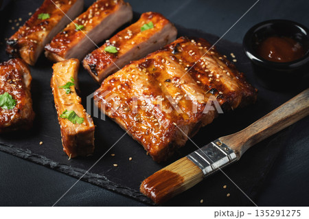 Barbecue pork spare ribs with hot honey chili marinade on black background Barbecue pork spare ribs with hot honey chili marinade on black background 135291275