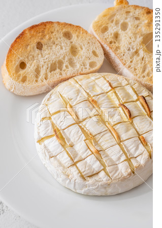 Baked camembert with toasted ciabatta garlic and rosemary garnish 135291350
