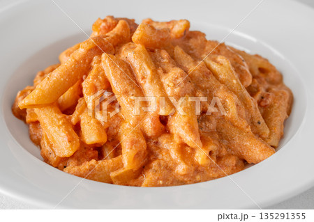 Penne pasta in creamy ricotta tomato sauce with grated parmesan cheese Penne pasta in creamy ricotta tomato sauce with grated parmesan cheese 135291355