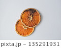 Two dehydrated orange slices stack against a simple white backdrop 135291931