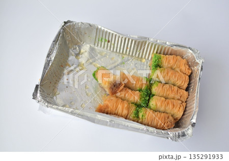 Close up shot of sweet rolls in aluminum tray on a white background 135291933