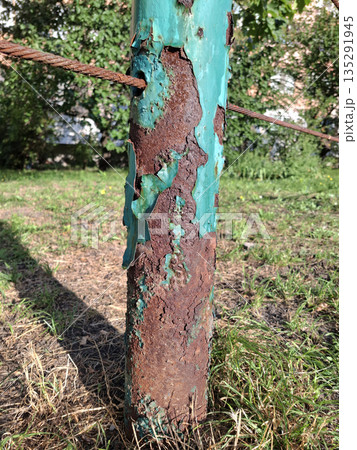 Metal corrosion. Old rusty cracked iron post with peeling blue paint Metal corrosion. Old rusty cracked iron post with peeling blue paint 135291945