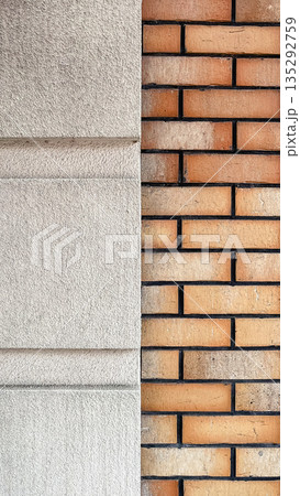 Modern architectural detail featuring a contrast between orange brickwork and grey textured plaster Modern architectural detail featuring a contrast between orange brickwork and grey textured plaster 135292759