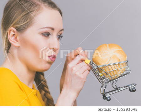 Woman holding shopping cart with bread 135293648