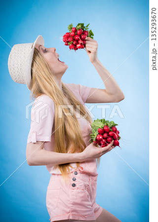 Young woman holding radish Young woman holding radish 135293670