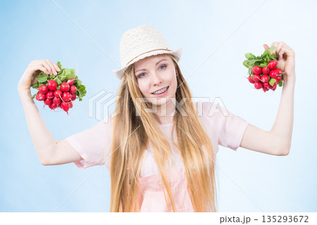 Young woman holding radish Young woman holding radish 135293672