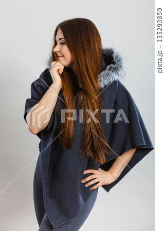 Happy woman wearing dark poncho with hood Happy woman wearing dark poncho with hood 135293850