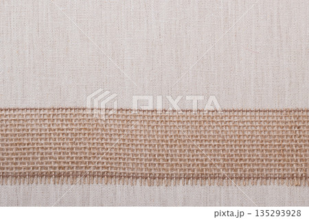 Jute ribbon on linen cloth background Jute ribbon on linen cloth background 135293928