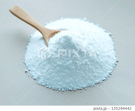 Eco-friendly trends. Pile of powdered detergent with a wooden spoon on a white background. Eco-friendly trends. Pile of powdered detergent with a wooden spoon on a white background. 135294442