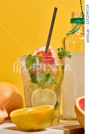 Glass with cold cocktail, citrus pieces inside, homemade drink Glass with cold cocktail, citrus pieces inside, homemade drink 135294514