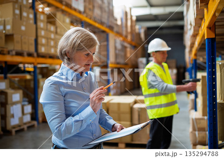 Senior woman manager and man worker working in a warehouse. 135294788