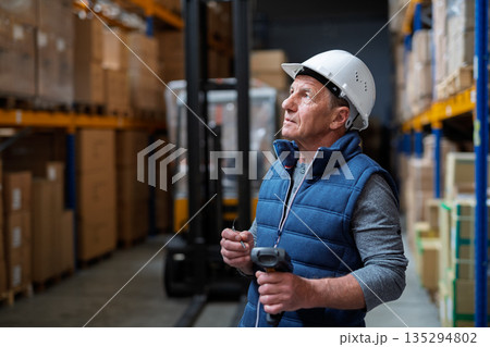 Portrait of mature warehouse worker with helmet. 135294802