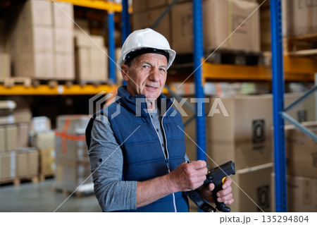 Portrait of mature warehouse worker with helmet. 135294804
