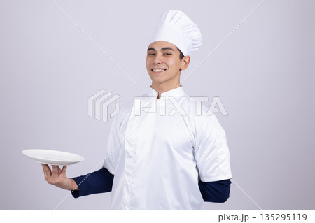Professional chef holding empty plate for serving Professional chef holding empty plate for serving 135295119