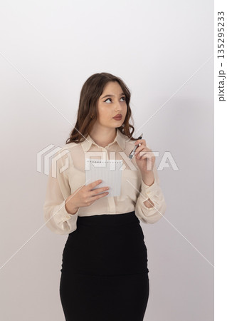 Pensive business woman holding documents in office Pensive business woman holding documents in office 135295233