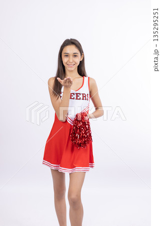 Cheerful cheerleader woman in red uniform Cheerful cheerleader woman in red uniform 135295251