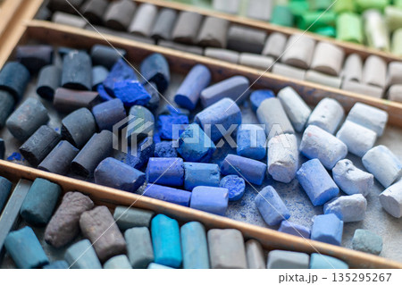 Blue gray soft pastels crayons collection in wooden case. Painter's multicolor background. Chalk pieces top view Blue gray soft pastels crayons collection in wooden case. Painter's multicolor background. Chalk pieces top view 135295267
