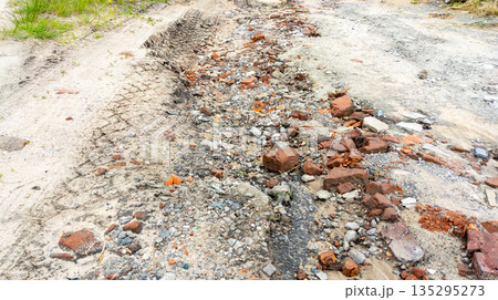Old muddy country road with deep tire tracks and potholes left by rain, indicating poor condition Old muddy country road with deep tire tracks and potholes left by rain, indicating poor condition 135295273