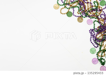 Mardi gras beads and doubloons on white background 135295433