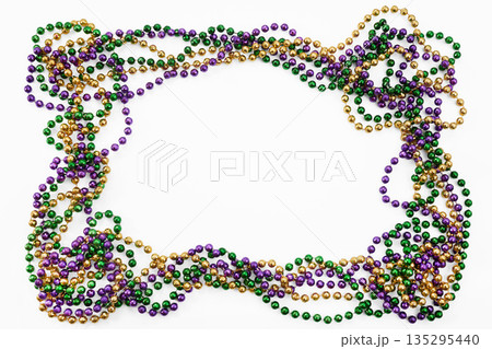 Mardi gras beads forming an oval frame on white background 135295440