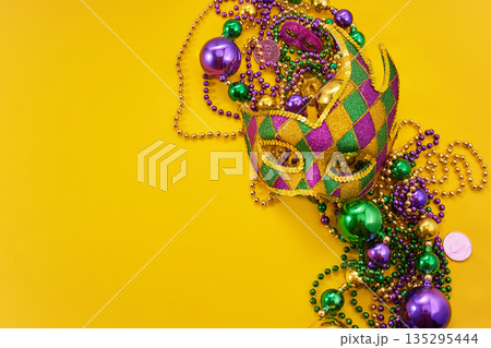 Mardi gras mask and beads on yellow background 135295444