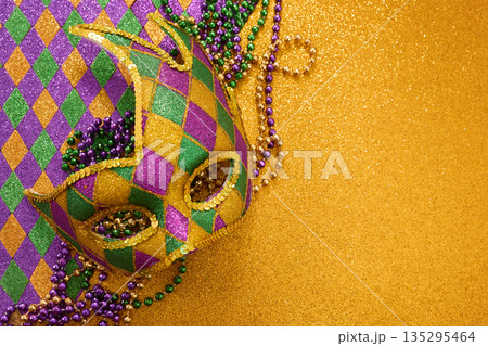 Mardi gras carnival mask with colorful beads on glitter Mardi gras carnival mask with colorful beads on glitter 135295464
