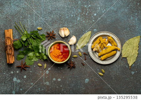 Various Indian spices and herbs arranged on a rustic background . 135295538