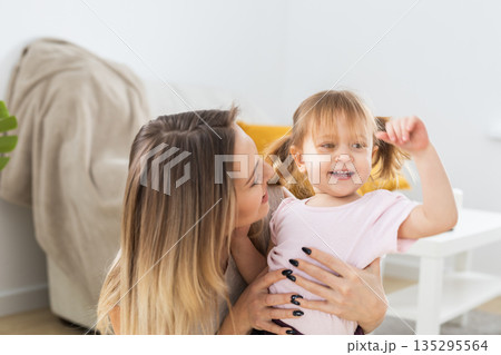 Mother and daughter spending time together at home. Family connection, parenting, communication, and everyday life in a cozy domestic interior. Mother and daughter spending time together at home. Family connection, parenting, communication, and everyday life in a cozy domestic interior. 135295564