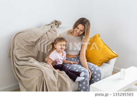 Mother and daughter spending time together at home. Family connection, parenting, communication, and everyday life in a cozy domestic interior. Mother and daughter spending time together at home. Family connection, parenting, communication, and everyday life in a cozy domestic interior. 135295565