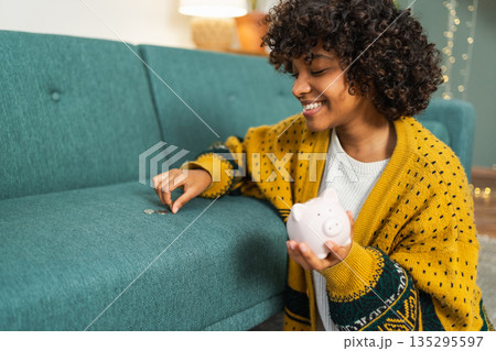 Saving money investment for future. African American girl holding pink piggy bank and putting money coin. Saving investment budget business wealth retirement financial money banking concept 135295597