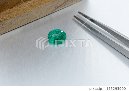 macro mineral faceted stone Emeralds on a gray background macro mineral faceted stone Emeralds on a gray background 135295990