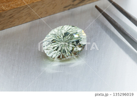 macro mineral faceted stone cut Beryl on a gray background macro mineral faceted stone cut Beryl on a gray background 135296019