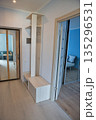 Modern hallway interior with white storage unit and mirror doors. 135296531