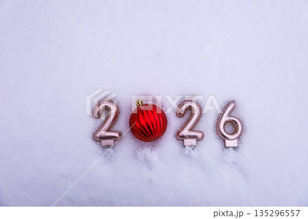 Stylish New Year 2026 winter scene with a ribbed red Christmas ornament replacing zero on snowy surface Stylish New Year 2026 winter scene with a ribbed red Christmas ornament replacing zero on snowy surface 135296557