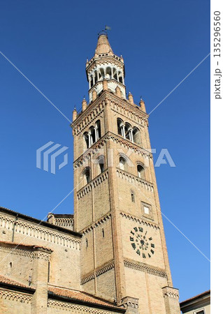 Low angle view of the historical Torrazzo, the iconic brick bell tower of the Cathedral of Santa Maria Assunta in Crema, Cremona province, Italy. Medieval architecture with a large clock under a clear Low angle view of the historical Torrazzo, the iconic brick bell tower of the Cathedral of Santa Maria Assunta in Crema, Cremona province, Italy. Medieval architecture with a large clock under a clear 135296560