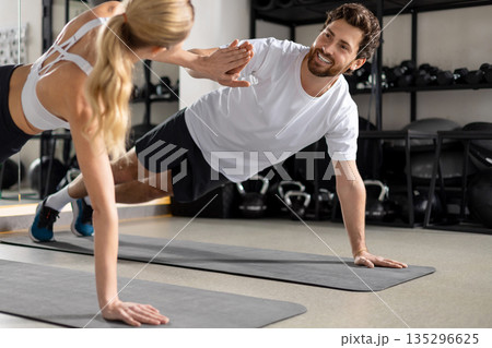Man and woman exercising together and looking contented and determined Man and woman exercising together and looking contented and determined 135296625
