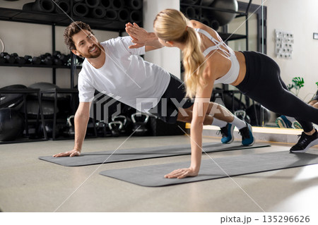 Man and woman exercising together and looking contented and determined 135296626