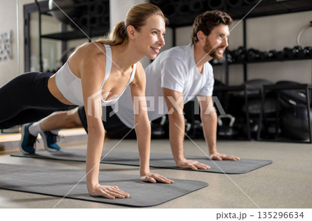 Two young people exercising together and standing in a plank 135296634
