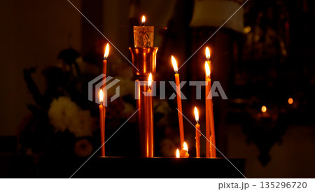 Candles burn in the dark hall of the Orthodox church near the altar 135296720