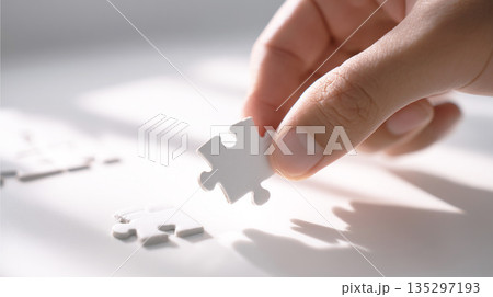 パズルのピースをはめようとする手元 ビジネス 135297193