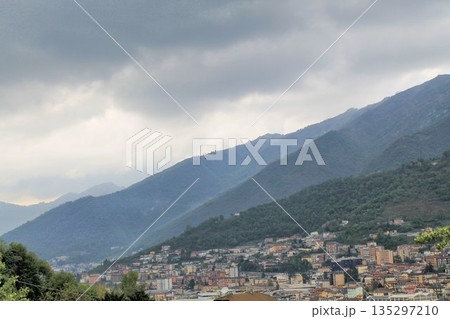 Panoramic view of Lumezzane, a famous industrial hub in Val Trompia, Brescia province, Italy. Houses and factories built on the steep mountain slopes of the Italian Prealps under a cloudy sky. 135297210