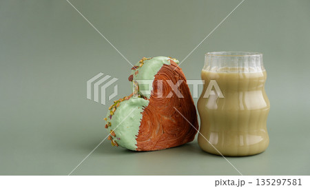 Green tea Matcha latte cappuccino beverage Morning breakfast gift idea Heart shaped pistachio croissant on green background with copy space. Puff pastry trendy sweet dessert bakery. Creamy dough Green tea Matcha latte cappuccino beverage Morning breakfast gift idea Heart shaped pistachio croissant on green background with copy space. Puff pastry trendy sweet dessert bakery. Creamy dough 135297581
