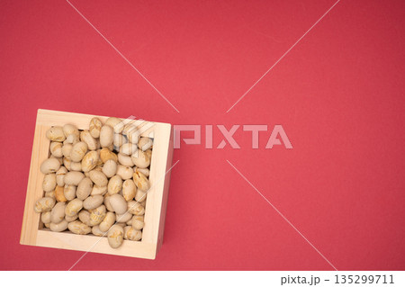 木枡に盛った豆を赤背景で撮影した物撮り 135299711